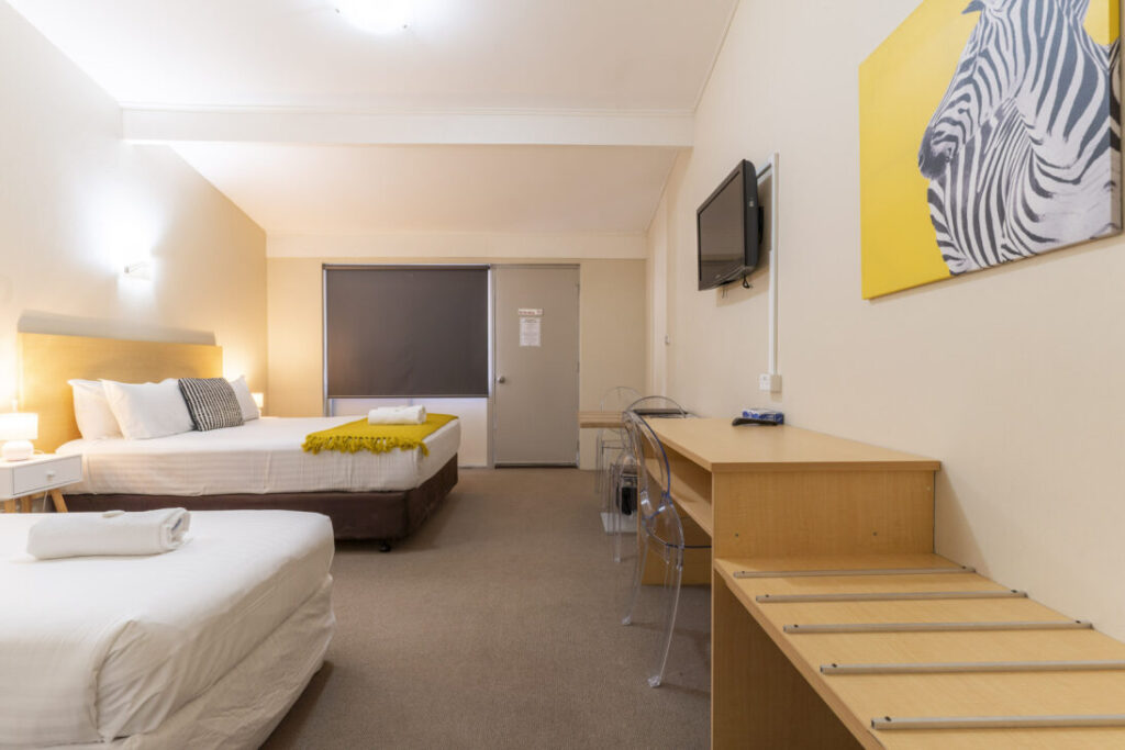 Modern hotel room with two beds and desk in Albany WA